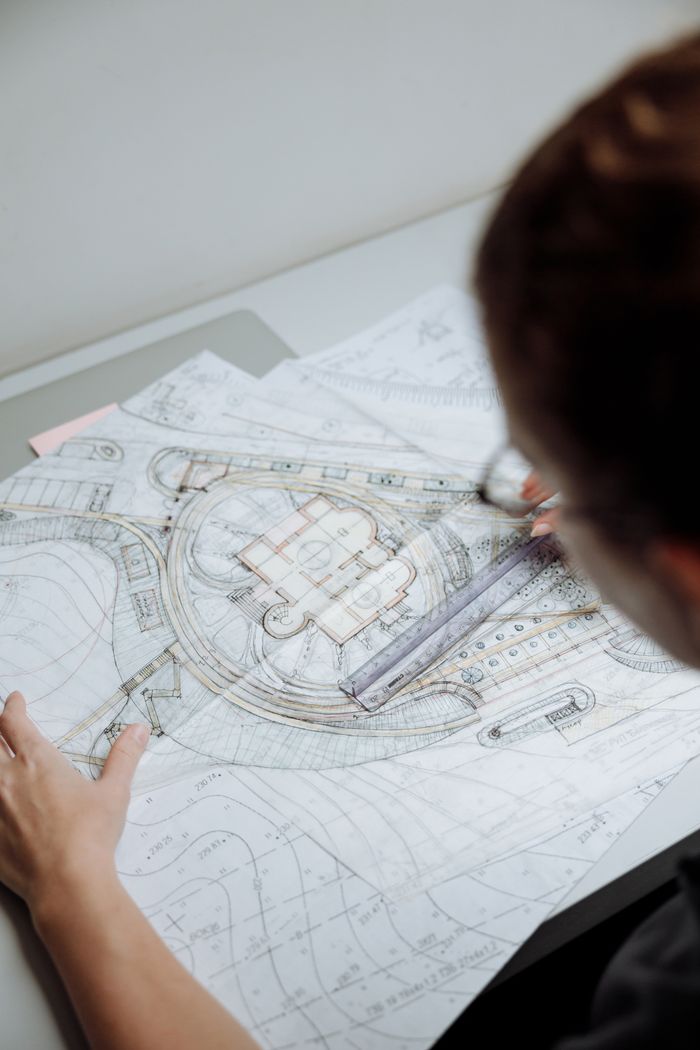 The Art of Drawing Readers In: Your attractive post title goes here Professional architect analyzing detailed blueprints at a workplace.